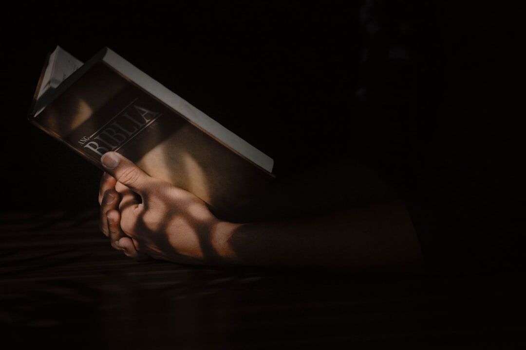 person reading book in dim light